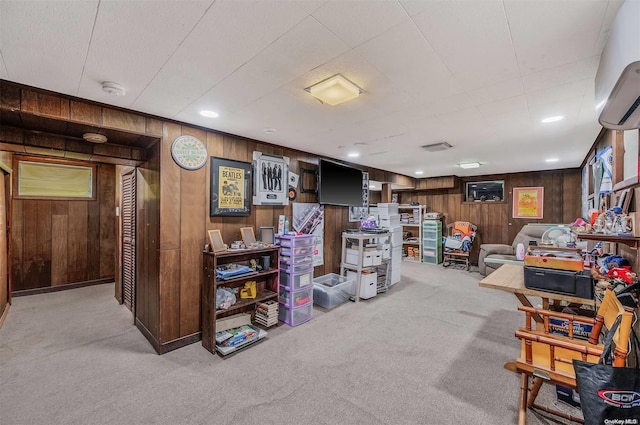 interior space with a wall unit AC, wood walls, and light carpet