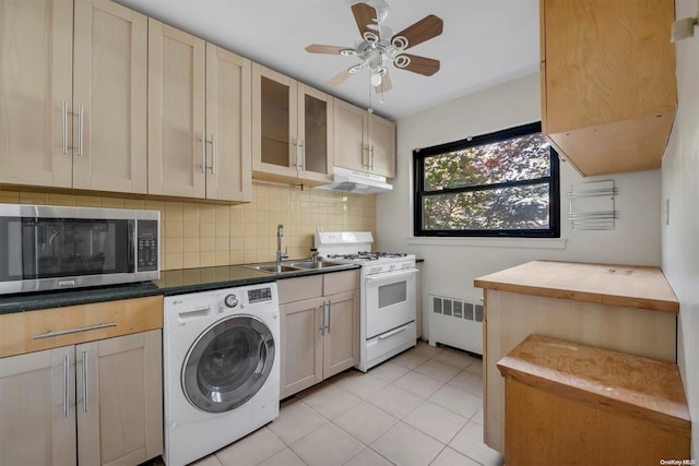 clothes washing area featuring sink, ceiling fan, light tile patterned flooring, washer / dryer, and radiator heating unit