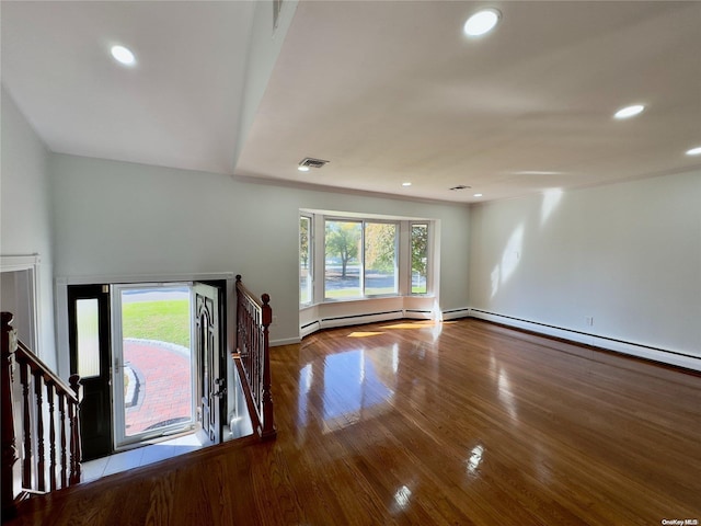 unfurnished living room with baseboard heating and light hardwood / wood-style flooring