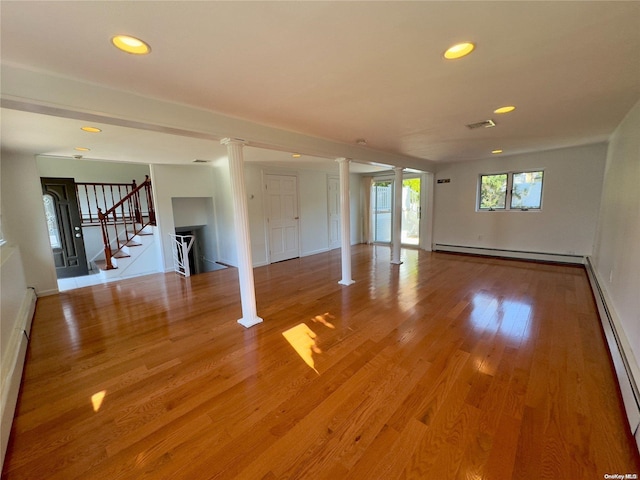 unfurnished living room with hardwood / wood-style flooring and a baseboard radiator