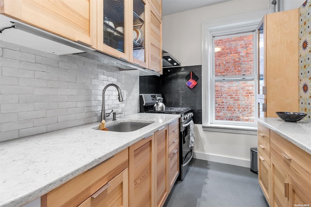 kitchen with light stone countertops, backsplash, sink, light brown cabinets, and stainless steel electric range oven