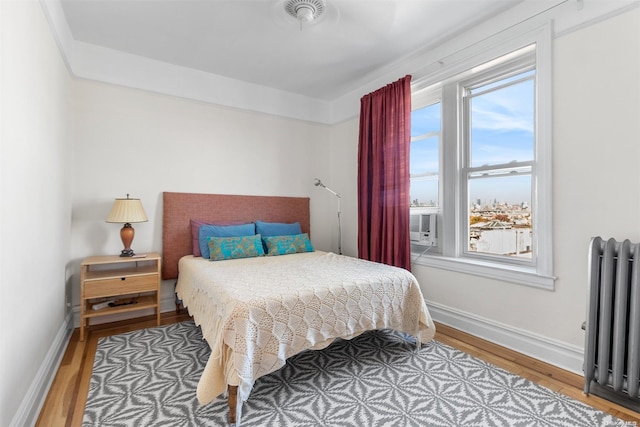 bedroom with wood-type flooring and radiator