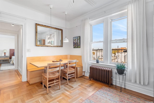 dining space with radiator, breakfast area, and light parquet floors