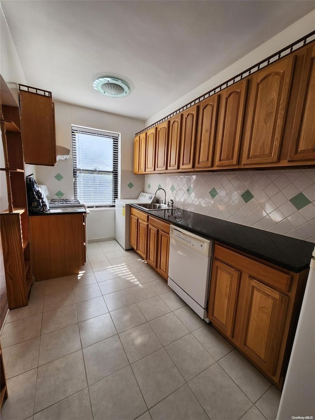 kitchen with sink, washer / clothes dryer, white dishwasher, decorative backsplash, and light tile patterned flooring