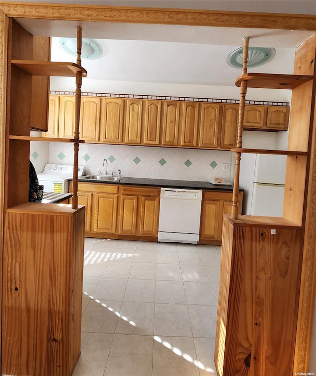 kitchen featuring decorative backsplash, sink, light tile patterned floors, and white appliances