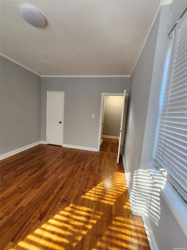 unfurnished room with hardwood / wood-style floors and ornamental molding