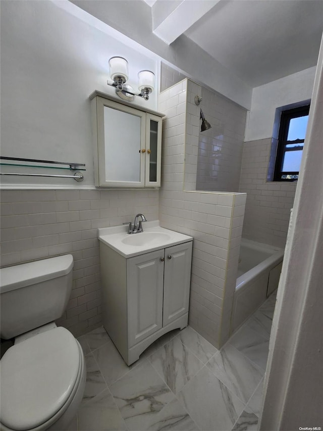 bathroom with vanity, toilet, and tile walls