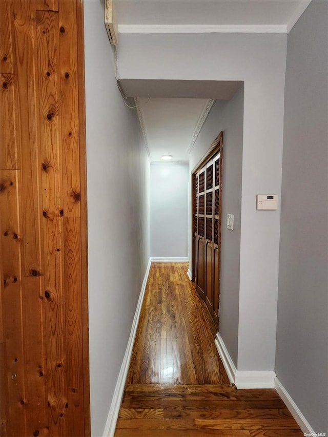 corridor with dark hardwood / wood-style floors and crown molding