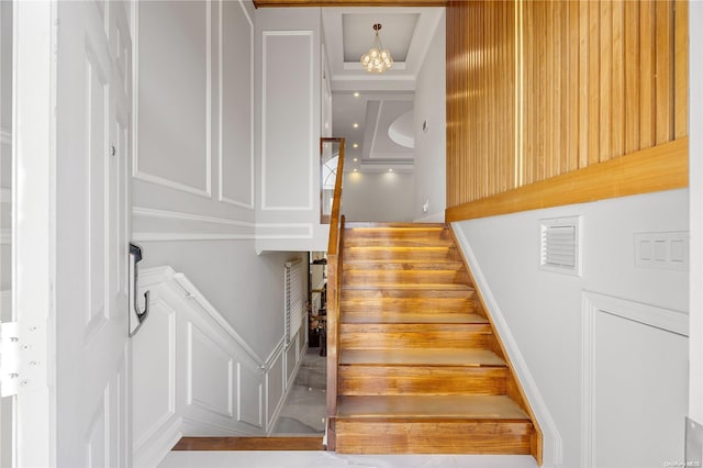 staircase with an inviting chandelier