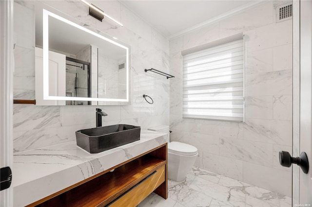 bathroom with vanity, an enclosed shower, tile walls, and toilet