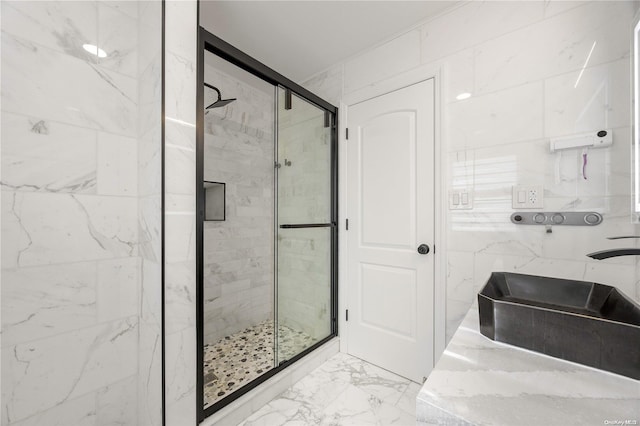 bathroom featuring a shower with door, sink, and tile walls