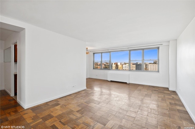 spare room featuring radiator heating unit and parquet floors