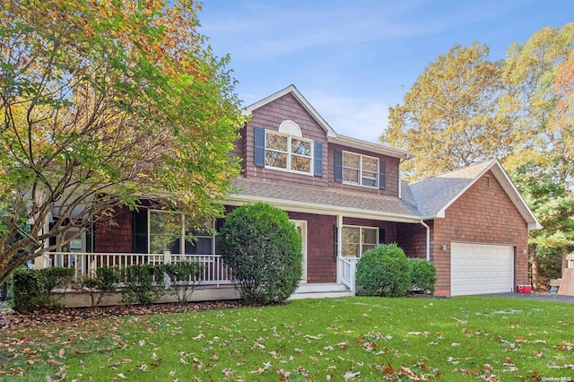 view of front of property with a front lawn, covered porch, and a garage