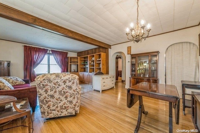 interior space with a chandelier, light wood-type flooring, and beamed ceiling