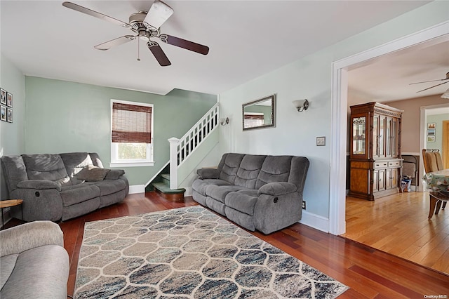 living room featuring ceiling fan and dark wood-type flooring