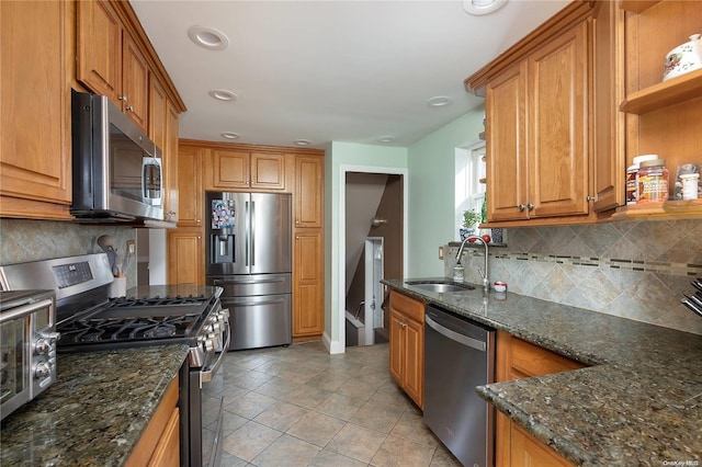 kitchen with decorative backsplash, dark stone counters, stainless steel appliances, sink, and light tile patterned flooring