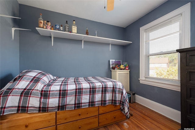 bedroom with hardwood / wood-style flooring, multiple windows, and ceiling fan