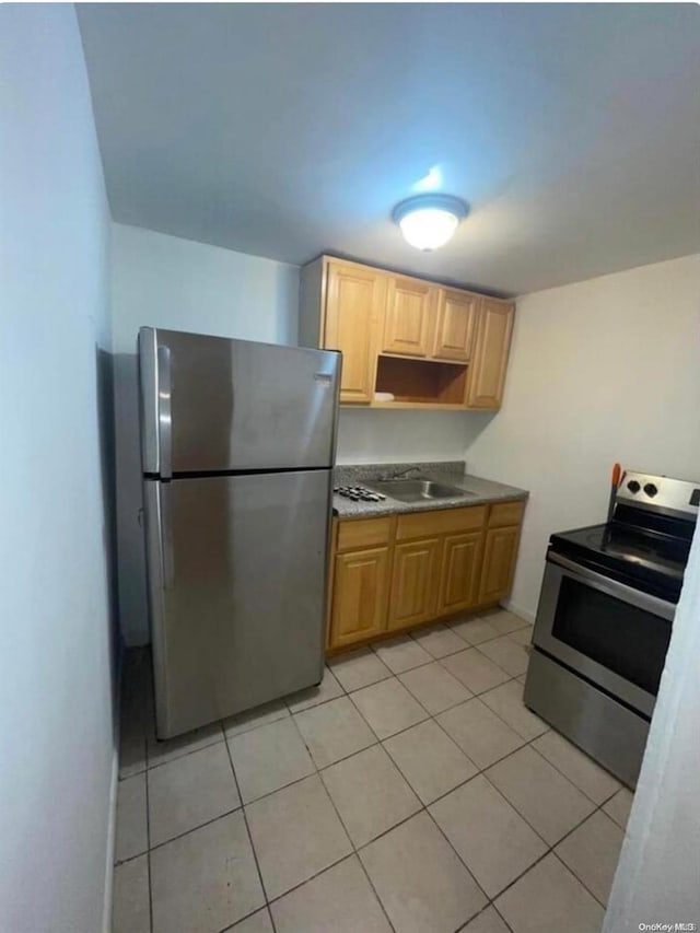 kitchen with light brown cabinets, sink, light tile patterned floors, and stainless steel appliances