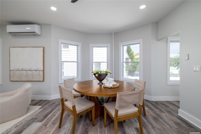 dining room with a wall unit AC, plenty of natural light, and dark wood-type flooring