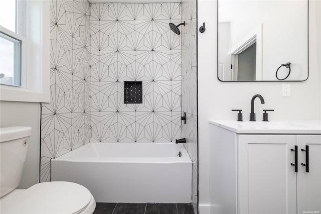 full bathroom with tile patterned flooring, vanity, tiled shower / bath combo, and toilet