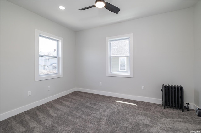 carpeted empty room with radiator heating unit and ceiling fan