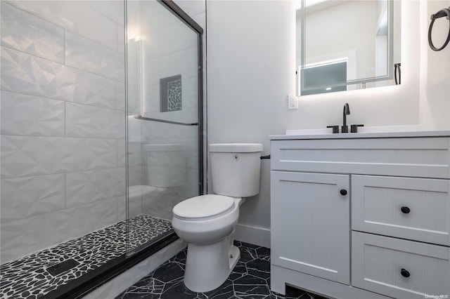 bathroom featuring a tile shower, vanity, and toilet