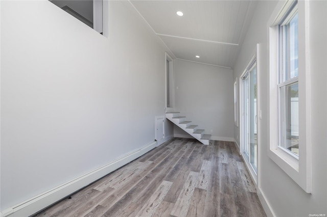 interior space with baseboard heating, a wealth of natural light, and light hardwood / wood-style flooring