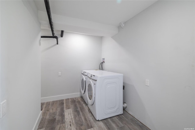 clothes washing area with hardwood / wood-style floors and washing machine and clothes dryer