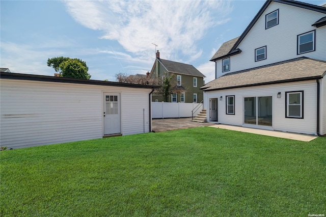 rear view of property featuring a lawn and a patio area