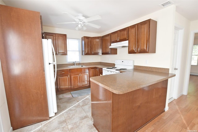 kitchen with kitchen peninsula, light wood-type flooring, white appliances, ceiling fan, and sink