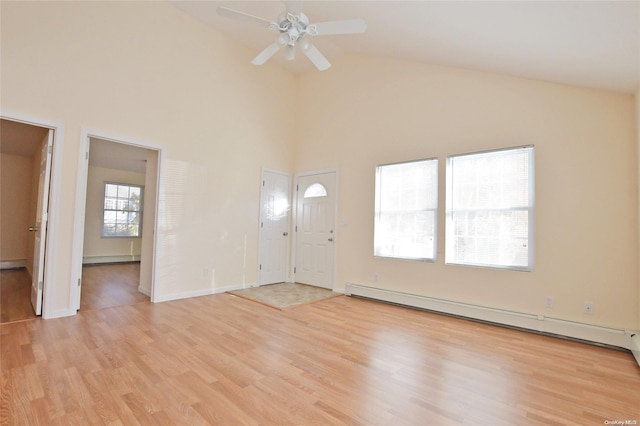 unfurnished living room with plenty of natural light, a baseboard radiator, and light hardwood / wood-style floors