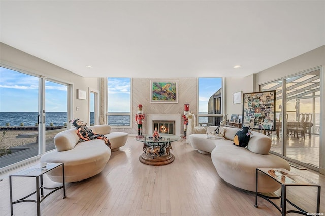 living room with a water view and light hardwood / wood-style flooring