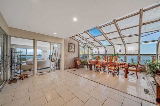 sunroom / solarium featuring a water view and vaulted ceiling