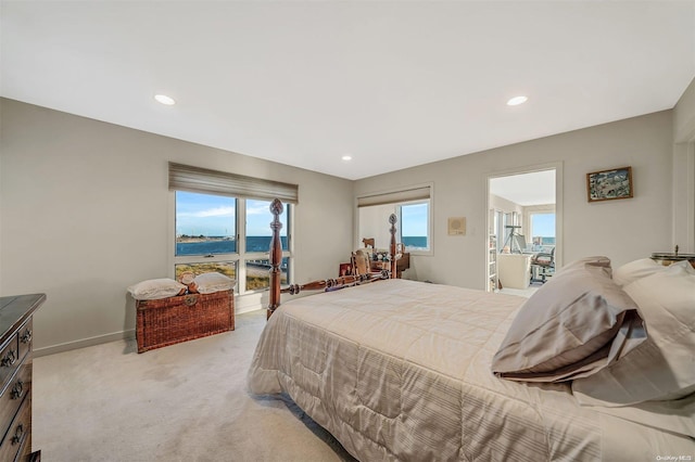 bedroom featuring a water view and light colored carpet