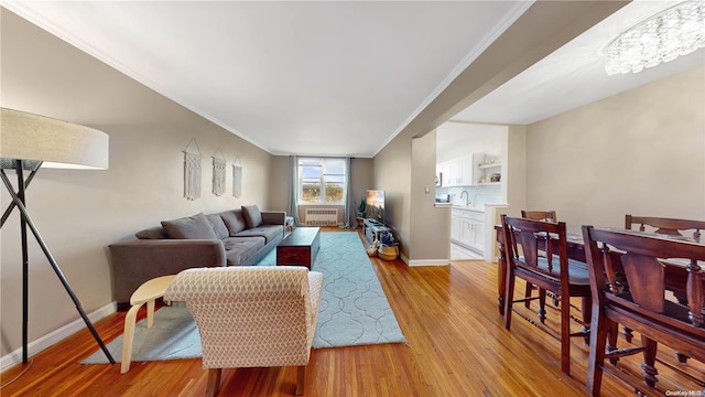 living room with crown molding, cooling unit, and light hardwood / wood-style floors