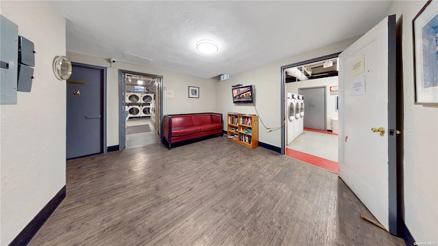 living area featuring dark hardwood / wood-style flooring and stacked washer / dryer