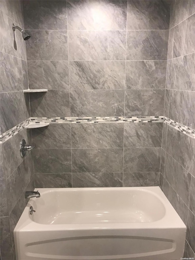 bathroom featuring tiled shower / bath