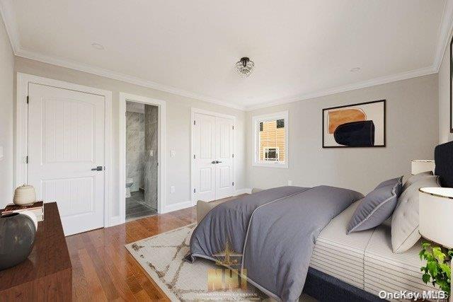 bedroom with connected bathroom, dark hardwood / wood-style flooring, and ornamental molding