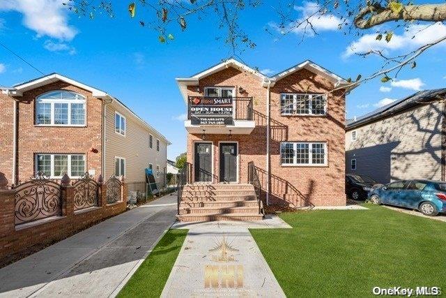 view of front facade with a balcony and a front yard