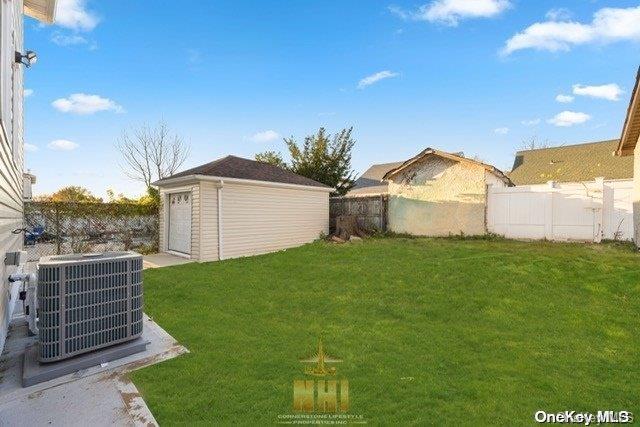 view of yard featuring central AC and an outbuilding