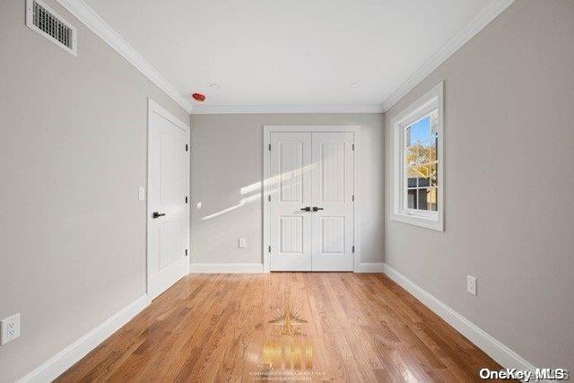 unfurnished bedroom with crown molding and light hardwood / wood-style flooring