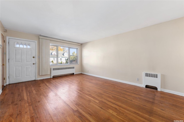 interior space with radiator and hardwood / wood-style floors