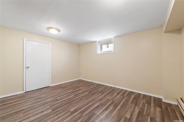 basement featuring dark hardwood / wood-style floors and a baseboard heating unit