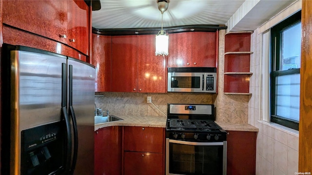 kitchen with sink, stainless steel appliances, tasteful backsplash, plenty of natural light, and decorative light fixtures