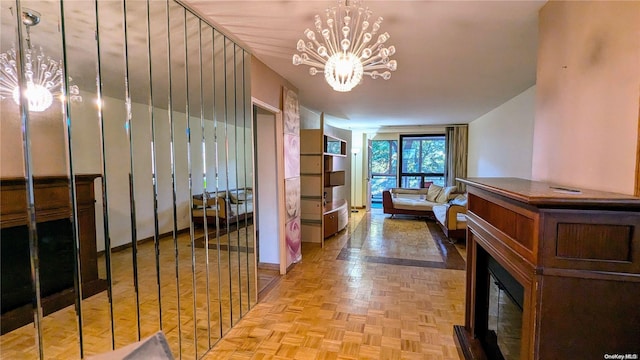 hallway with a chandelier and light parquet flooring