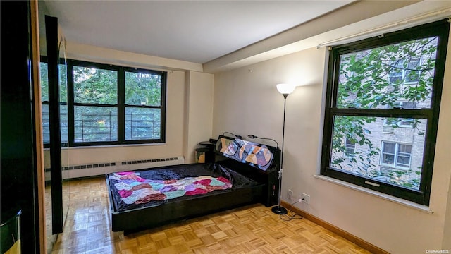 bedroom featuring light parquet flooring and a baseboard radiator