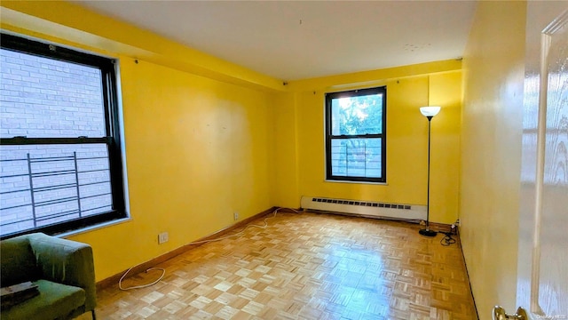 unfurnished room with baseboard heating and parquet floors