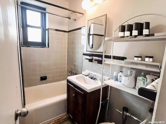 bathroom with decorative backsplash, vanity, and tiled shower / bath combo