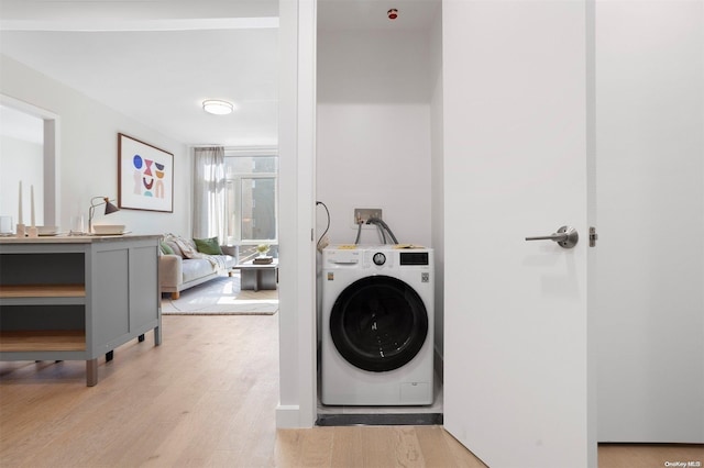 laundry room with washer / clothes dryer and light hardwood / wood-style floors