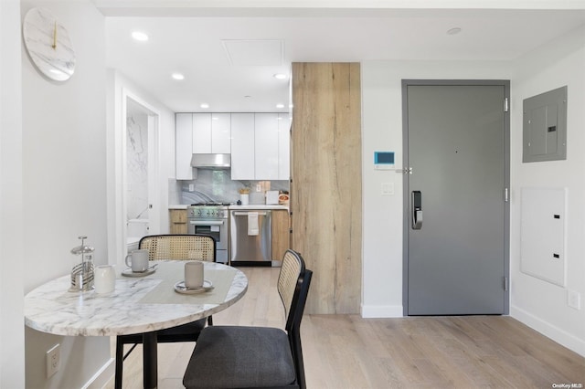 dining area with electric panel and light hardwood / wood-style flooring